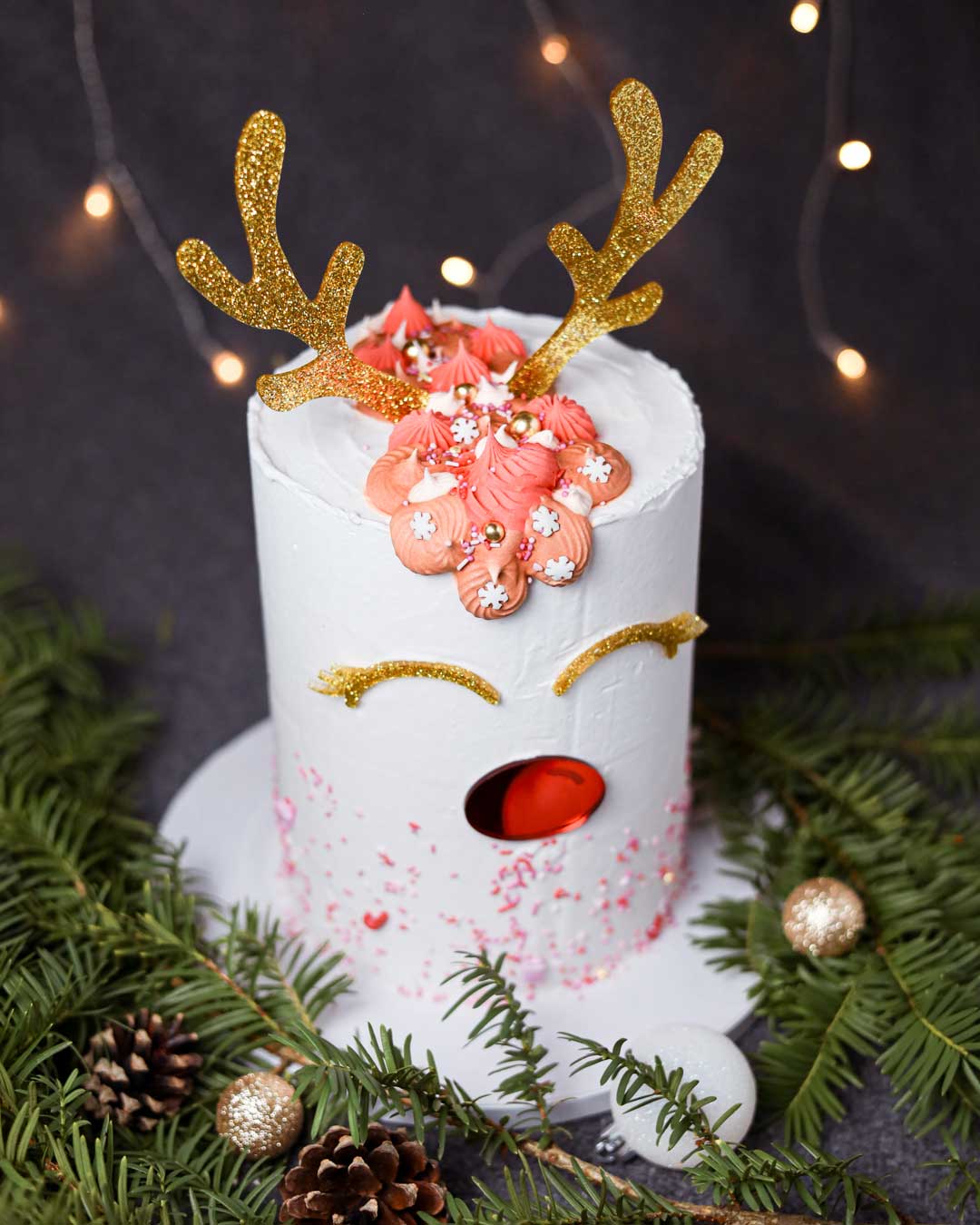 Cake Topper Set Glitzerndes Rentier mit goldenen Geweihen und roter Nase auf weißer Weihnachtstorte