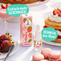 SuperAroma Erdbeere – Backaroma Fläschchen mit Pipette umgeben von Erdbeerdesserts, Macarons und Kuchen