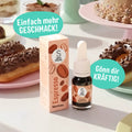 SuperAroma Espresso – Backaroma Fläschchen mit Donuts und Torte im Hintergrund